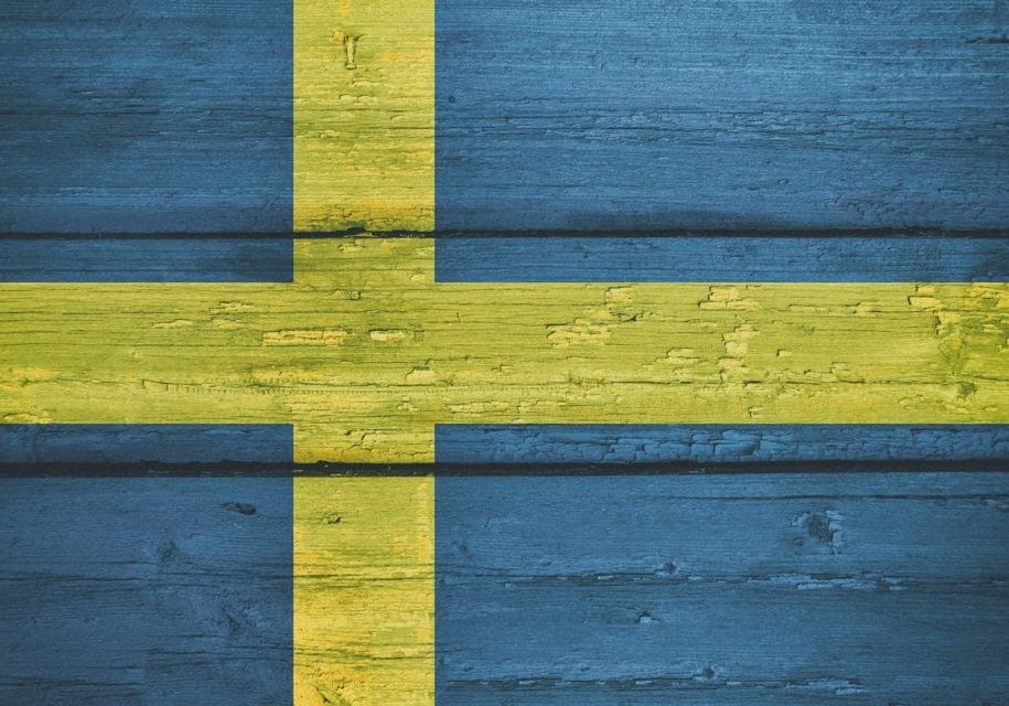 Bright Sweden National Flag on a Wooden Background.  Grunge Flags Texture